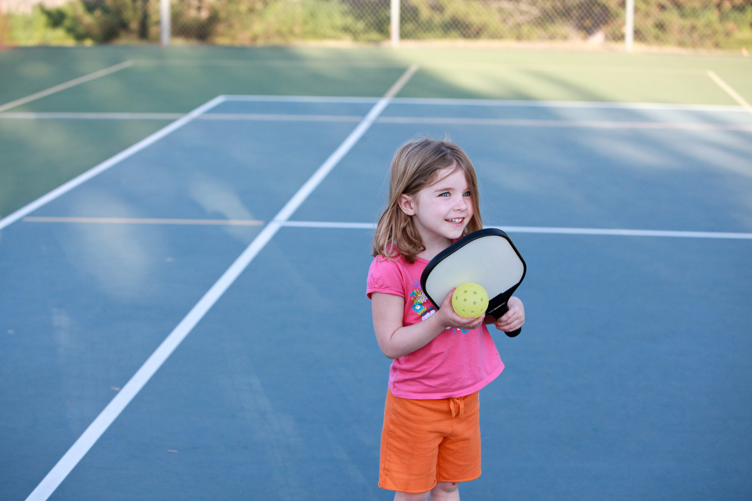 Young,Girl,Playing,Pickleball,On,An,Outdoor,Court.